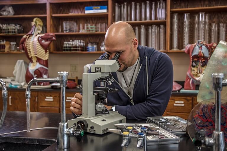African-American Student looking into microscope