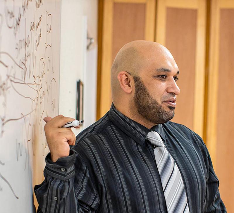 man pointing at white board