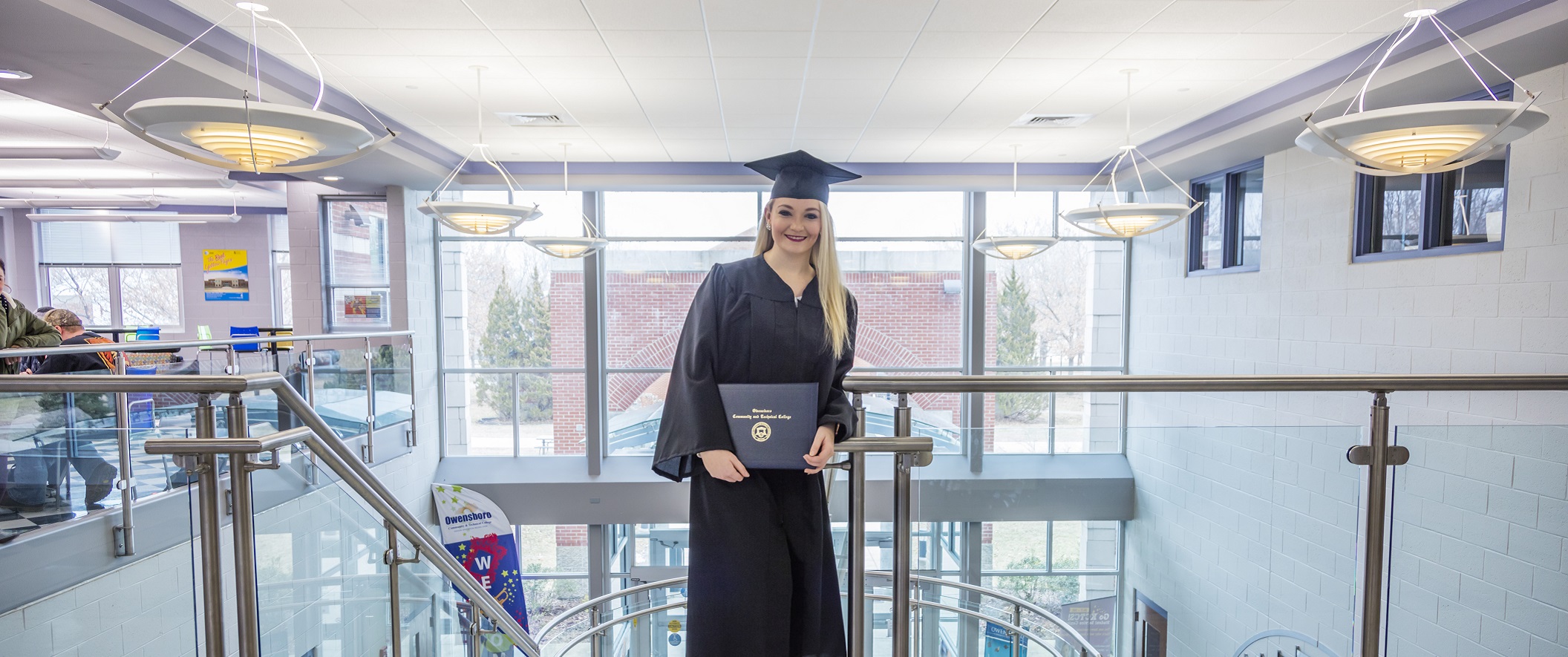 A new college grad poses with her diploma