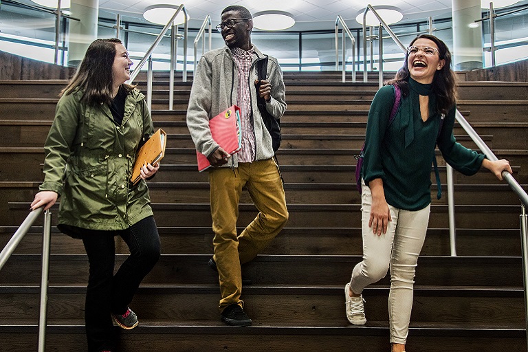 three students walking down stairs