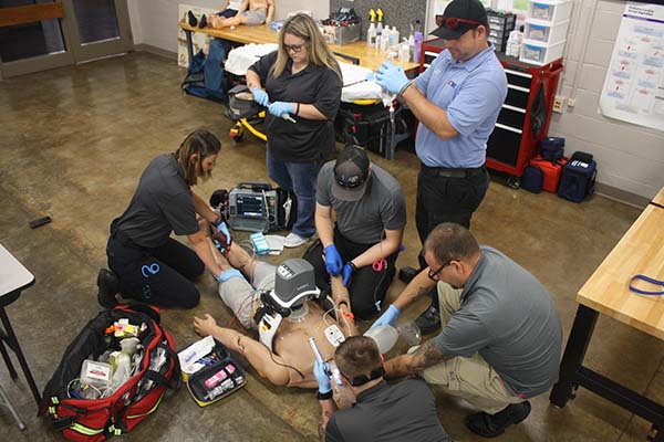 EMT students practicing on a manikin.