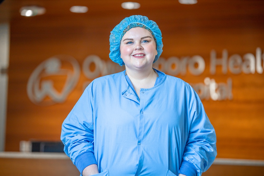 Individual in medical scrubs smiling for photo.